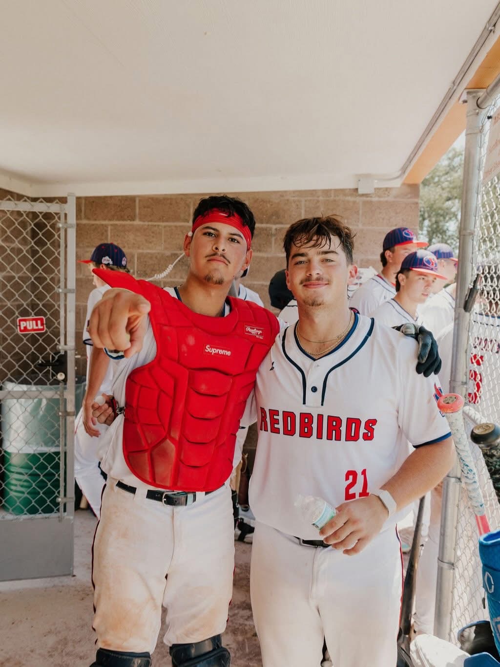 Two Redbirds baseball players in the dugout